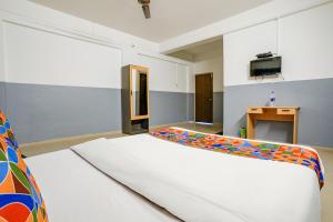 ナーシクにあるFabHotel Bhakti Sankulのベッドルーム1室(白い大型ベッド1台付)
