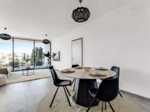 a white living room with a table and chairs at Sanders Park Central Residences in Limassol