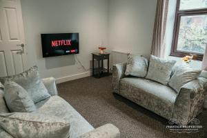 uma sala de estar com dois sofás e uma televisão em Fell Croft by Prestige Properties SA em Dalton in Furness