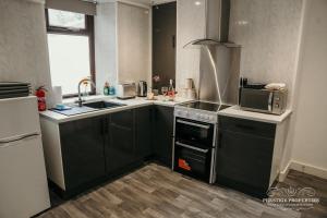 uma cozinha com um fogão, um lavatório e um micro-ondas em Fell Croft by Prestige Properties SA em Dalton in Furness