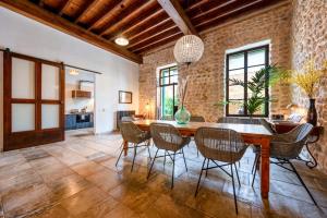 a dining room with a brick wall and a wooden table and chairs at Loft1882 in Sóller