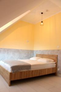 sypialnia z łóżkiem z drewnianą ramą w obiekcie APART MAZURY Apartamenty na Mazurach w Orzyszu