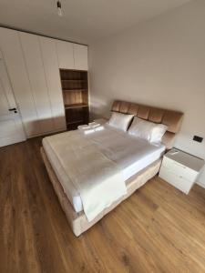 1 dormitorio con 1 cama grande y armarios blancos en Cloud 10 Apartment, en Vlorë