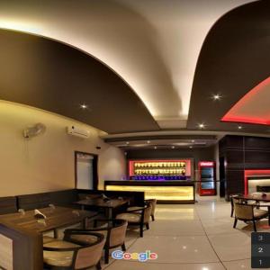 a restaurant with tables and chairs and a bar at Hotel Signature in Ichalkaranji