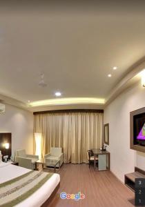 pokój hotelowy z łóżkiem i telewizorem w obiekcie Hotel Signature w mieście Ichalkaranji