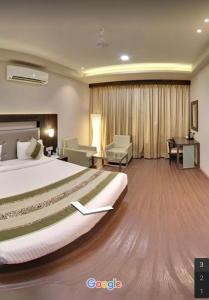 a hotel room with a large bed and a desk at Hotel Signature in Ichalkaranji