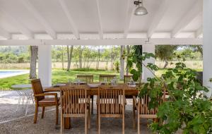 uma sala de jantar com uma mesa de madeira e cadeiras em El Vilar em Port de Pollensa