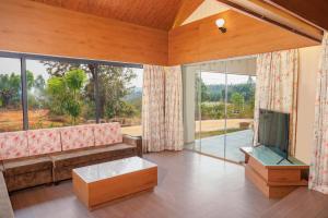 a living room with a couch and a tv at Urmilaa Green County Resort 35 KM From Kolhapur in Kolhapur
