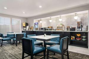 a restaurant with blue chairs and tables and a counter at La Quinta by Wyndham Hesperia Victorville in Hesperia