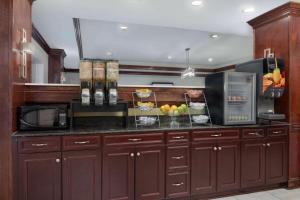 a kitchen with brown cabinets and a counter with fruit on it at La Quinta by Wyndham Savannah Airport - Pooler in Savannah