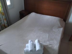 a bed with two towels sitting on top of it at Flat Theobald in Três Coroas