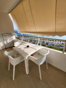 Una mesa blanca y sillas en una habitación con balcón. en Cloud 10 Apartment, en Vlorë