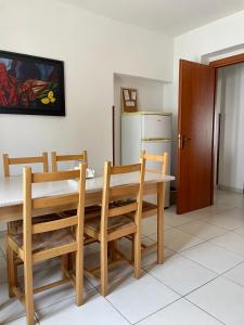 una cucina con tavolo, sedie e frigorifero di Villa Claudia - appartamento A a Corazzello