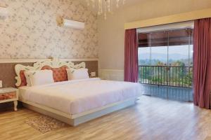 1 dormitorio con cama y ventana grande en Urmilaa Green County Resort 35 KM From Kolhapur, en Kolhapur
