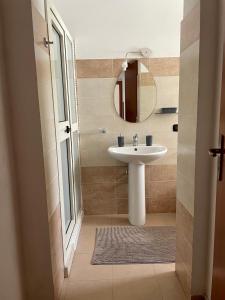 bagno con lavandino e specchio di Villa Claudia - appartamento A a Corazzello