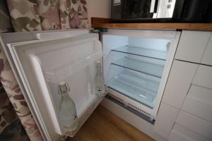 een open koelkast met twee glazen flessen erin bij Apartment 4 at Number 8 in City centre with kitchenette in Kent