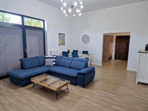 - un salon avec un canapé bleu et une table dans l'établissement Apartamenty Przy Latarni Kropla Bałtyku, à Darłówko