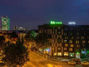 een gebouw met 's nachts een bord erop bij ibis Styles Bucharest Erbas in Boekarest