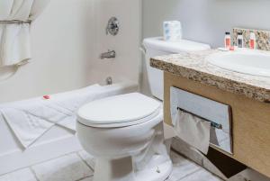 a bathroom with a white toilet and a sink at Travelodge by Wyndham Worland in Worland +24 photos