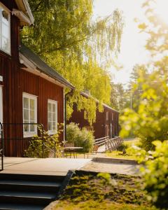 a red house with a porch and stairs to it at STF Korrö Hotell in Linneryd