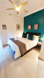 1 dormitorio con 1 cama con pared verde en Modern studio with private garden, self check-in, en Johannesburgo