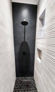 y baño con ducha y pared negra. en Modern studio with private garden, self check-in, en Johannesburgo