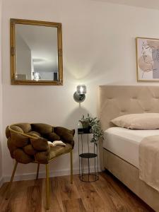 a bedroom with a bed and a mirror and a chair at Holiday Home Mirela in Orebić