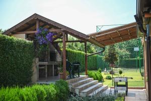 a wooden pergola with stairs in a garden at Guest House ERIDA in Trastenik