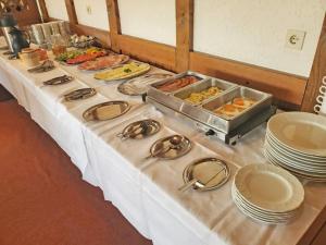 - une table sous forme de buffet avec des assiettes et de la nourriture dans l'établissement Landhotel Westerwaldgrill, à Höhn