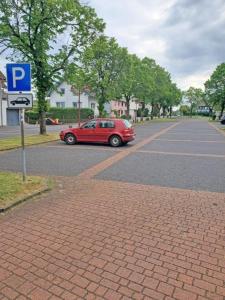 um carro vermelho estacionado ao lado de uma rua em Landhotel Westerwaldgrill em Höhn