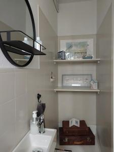 a bathroom with a sink and a black chandelier at Repos St Elisabeth nabij Plopsaland in De Panne