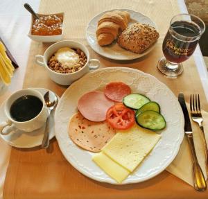 a table with two plates of breakfast foods and a cup of coffee at Landhotel Westerwaldgrill in Höhn +3 photos