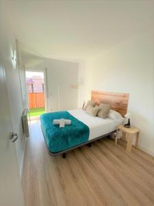 a bedroom with a large bed with a blue blanket at Apartamento Con Piscina y Gran Terraza con Vistas - Muy cerca de la playa, el centro y la estación in Vilassar de Mar