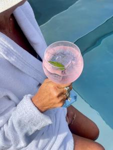 una persona che tiene un drink con un lime in un bicchiere di Hotell Dannegården a Trelleborg