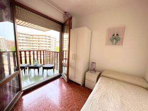 a bedroom with a bed and a balcony with a table at Espacioso apartamento con impresionantes vistas y garaje privado - Dos Torres Tauriel in Zaragoza