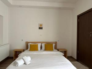 1 dormitorio con cama blanca y almohadas amarillas en "White House Nakani" - Guesthouse near the centre en Mestia