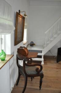 a living room with a chair and a staircase at Zauberhaftes englisches Cottage am Gutshaus in Groß Schoritz