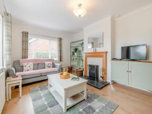 a living room with a couch and a tv at Moor Close in Alne
