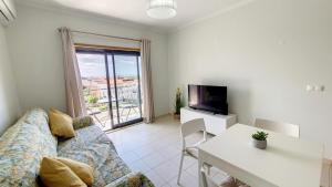 ein Wohnzimmer mit einem Sofa und einem Tisch in der Unterkunft Vista das Ondas 205 in Albufeira