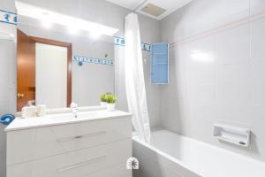 y baño blanco con lavabo y bañera. en Mediterranean Way - La Placeta en Cambrils