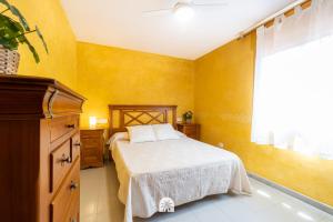 Un dormitorio con una cama con paredes amarillas y una ventana en Mediterranean Way - La Placeta en Cambrils