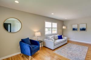 a living room with a white couch and a blue chair at Modern Rapid City Vacation Rental with Deck in Rapid City
