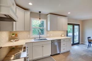 a kitchen with white cabinets and a sink at Modern Rapid City Vacation Rental with Deck in Rapid City