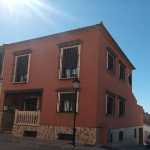 un edificio rojo con una luz de la calle delante de él en Casa El Albero (Torcal-Caminito del Rey), en La Joya