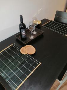 a black table with two glasses and a bottle of wine at Studio apartman Laca in Šibenik +10 photos