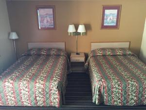 Una habitación de hotel con dos camas y dos lámparas. en Budget Inn - Cambridge, en Fairdale