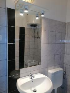 a bathroom with a white sink and a mirror at Studio apartman Laca in Šibenik