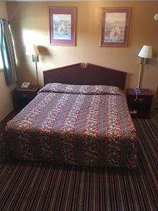a hotel room with a bed with a colorful blanket at Budget Inn - Cambridge in Fairdale