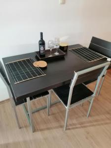 uma mesa preta com dois copos e uma garrafa de vinho em Studio apartman Laca em Sibenik