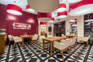 restauracja ze stołami, krzesłami i czerwonymi ścianami w obiekcie Hotel Swing w Krakowie
